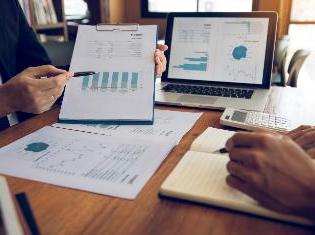 Two people reviewing charts and diagrams on clipboards.