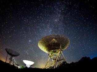 a view of the night sky with satellites in the foreground.